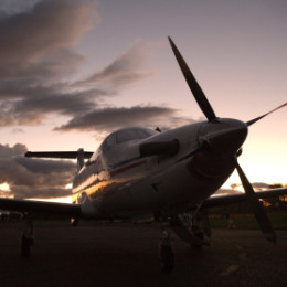 A single engine turbine aircraft at sunset